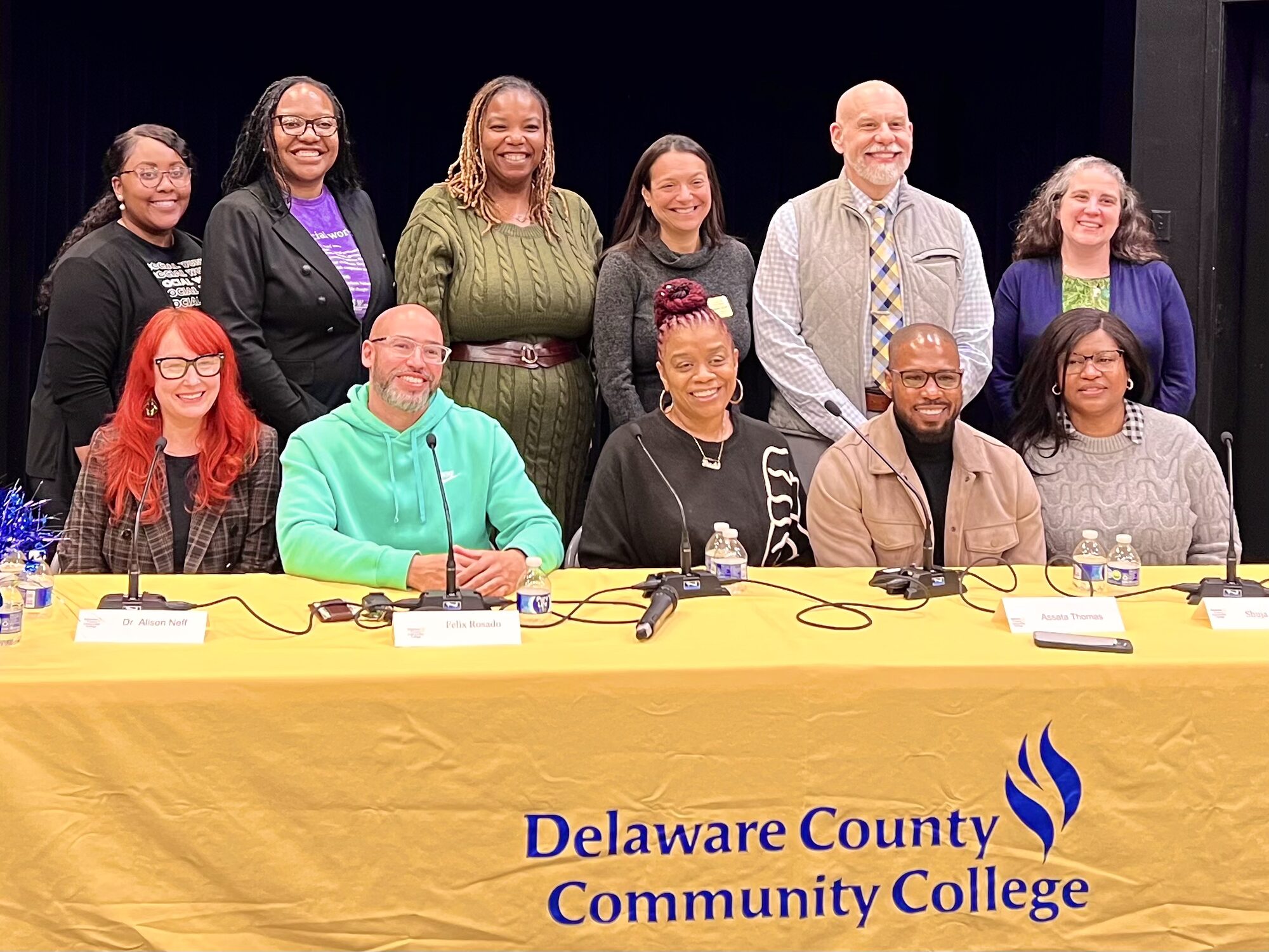 A panel seated behind a table at a college event