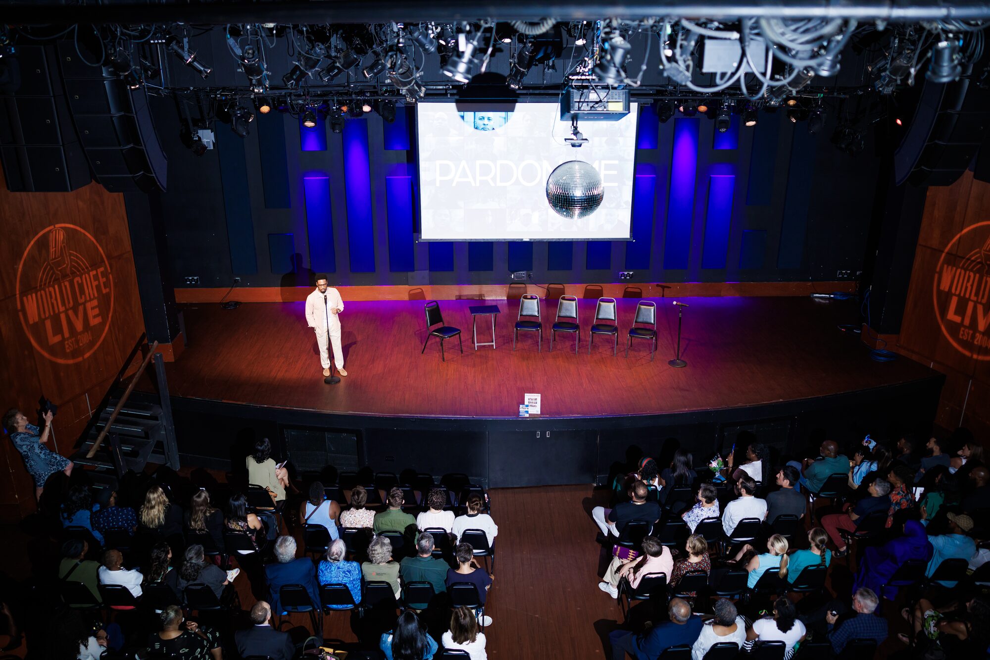 A full theater audience watching a stage presentation